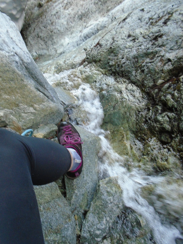 Trying to avoid the stream whilst belaying at the base of the route